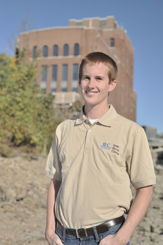 Dan Gilles in 2010, standing on the banks of the Iowa River, with Stanley Hydraulic Lab in the background