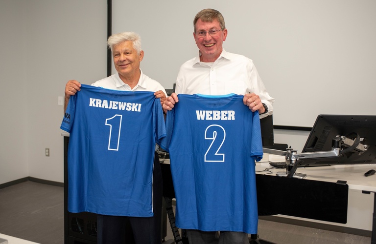 Witold Krajewski and Larry Weber receive soccer uniforms 