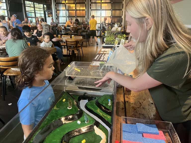 Child observes watershed model at the annual BioBlitz in 2024.