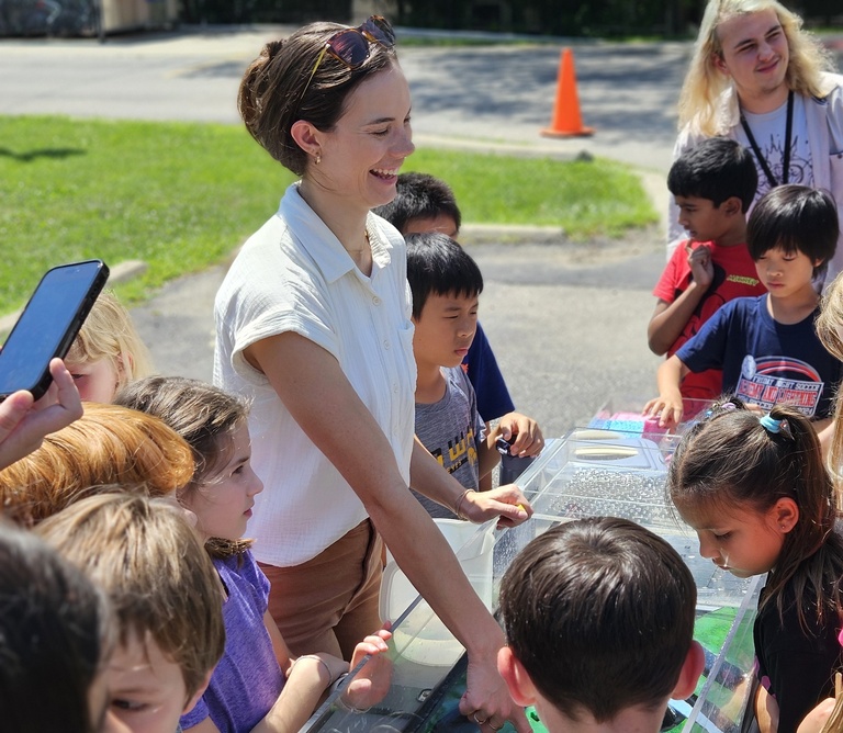 outreach event outdoors with students gathered around the watershed model
