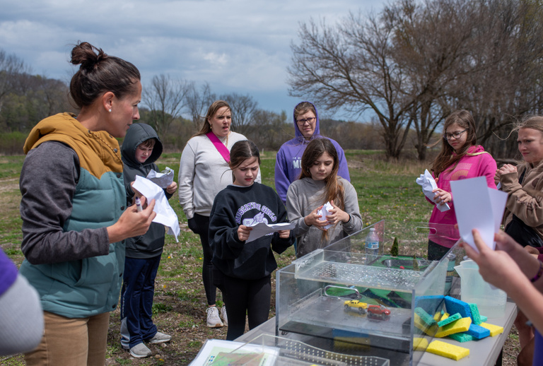 An outreach event at the LACMRERS facility, as students look at a watershed model located outside by the river