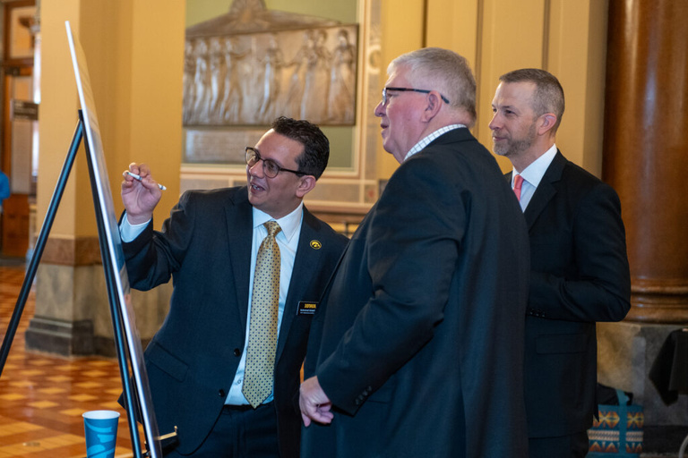 IFC staff member explains his research to legislators at the Legislative Breakfast event at the Iowa State Capital Rotunda