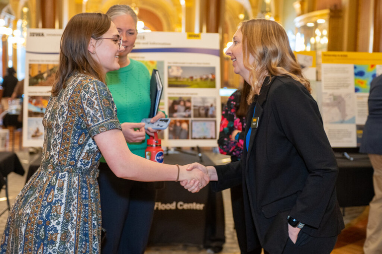 IFC staff shakes hands with a staff member at the Legislative Breakfast event at the Iowa State Capital Rotunda