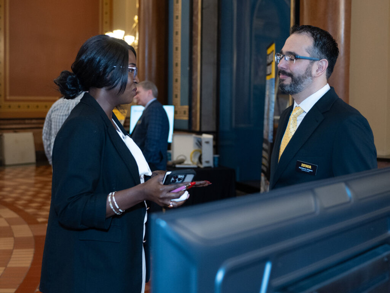 Humberto Vergara talks with a legislator at the Legislative Breakfast event at the Iowa State Capital Rotunda