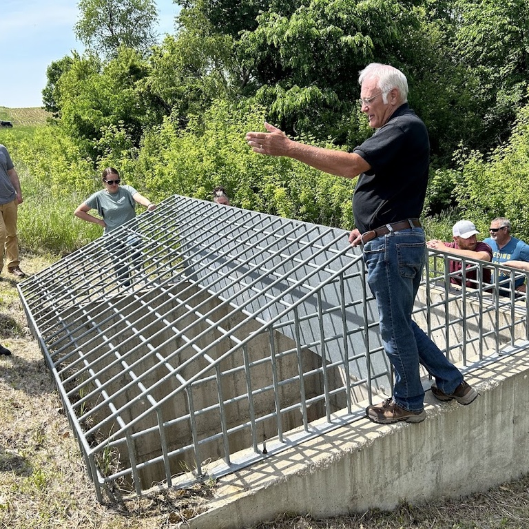 a group of people check out an on road structure on a steep hill